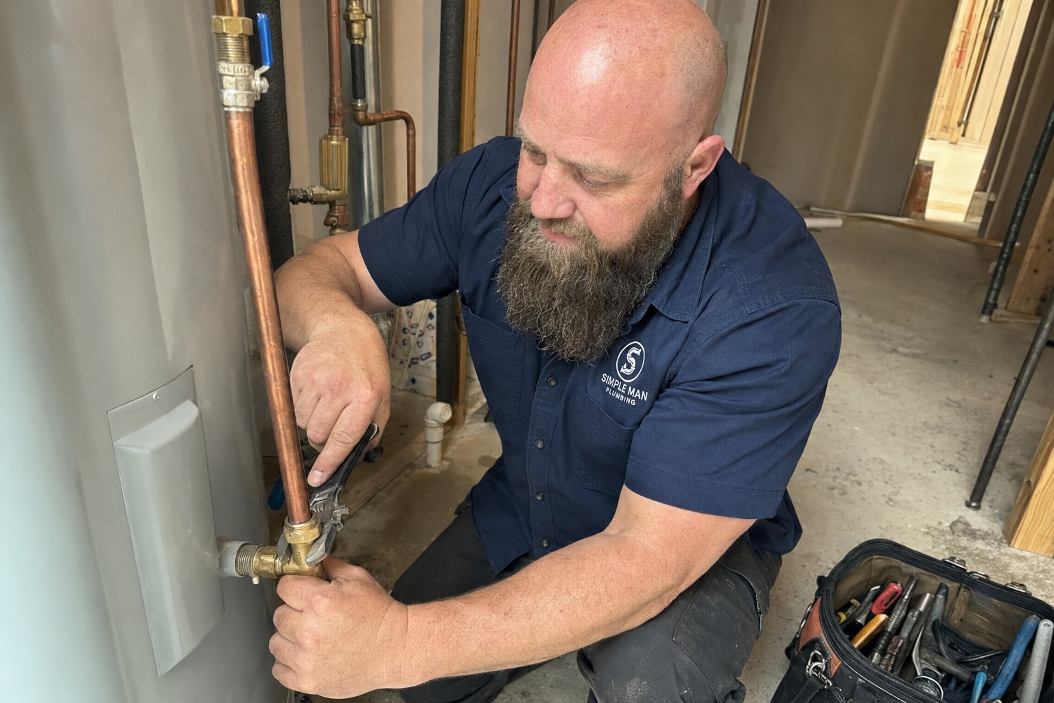 Dave servicing a water heater, checking the copper supply lines